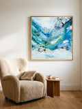 Square format art print in abstract style. The art poster is framed in oak ang hung above a soft armchair.