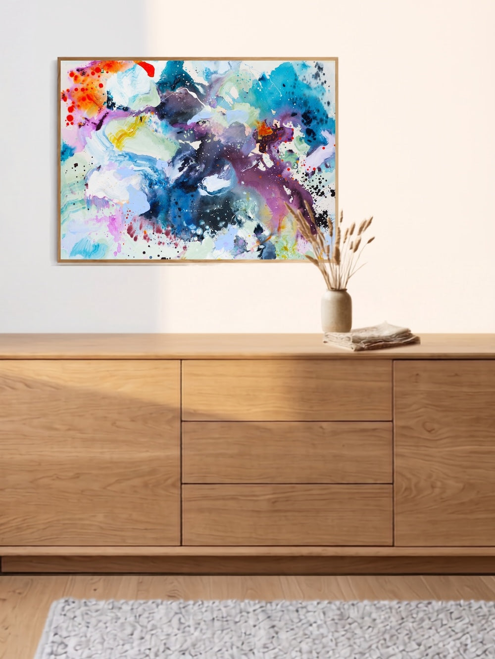 Horizontal abstract art print displayed above cabinet – interior styling by Mette Lindberg