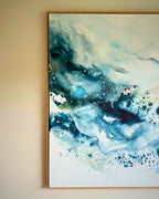 Close-up detail of large original abstract canvas painting in natural oak float frame – expressive fluid layers in teal, cobalt blue, navy and white with dynamic brushwork and fine paint splatter