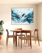 Large abstract blue art print in oak frame above round dining table by Mette Lindberg