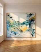 Large-scale abstract painting on canvas in teal, blue and gold tones with oak frame, leaning against a white wall in a sunlit Nordic room with herringbone oak parquet floor