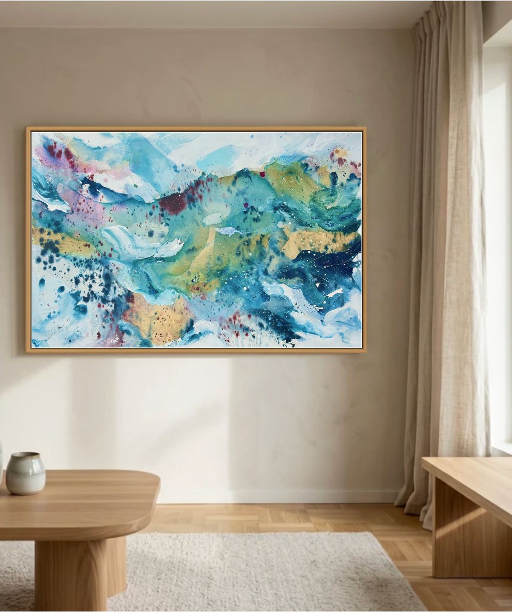 Expressive abstract canvas art with flowing teal, blue, gold and pink tones in oak frame. Handmade original painting by Mette Lindberg, Danish artist. 100x150 cm, unique piece
