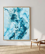Soft #14 – large original abstract canvas painting, 120x150 cm, in natural oak frame. Expressive fluid blue and teal waves by Danish artist Mette Lindberg, shown in Scandinavian interior setting