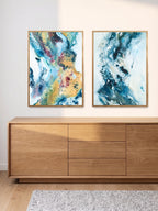 Two art posters in abstract style hanging above an oak cabinet.